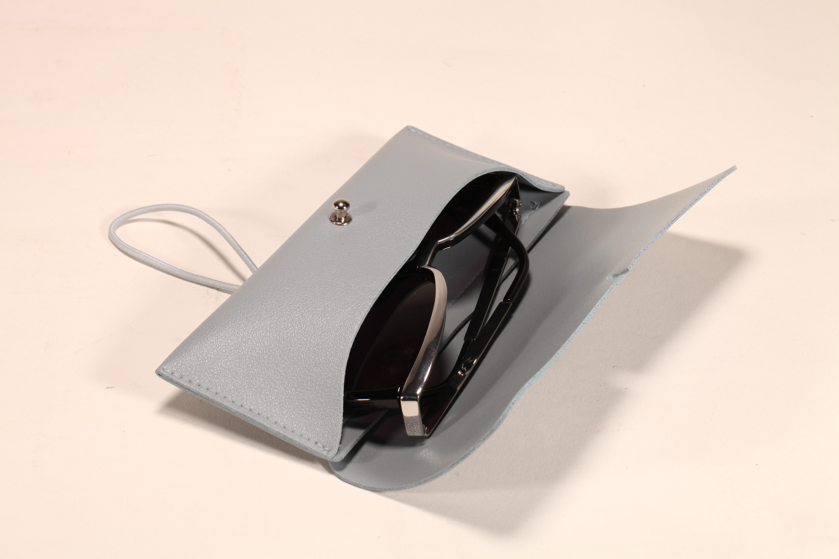 A soft case of light gray glasses, printed with LOGO and ICONS, small and delicate