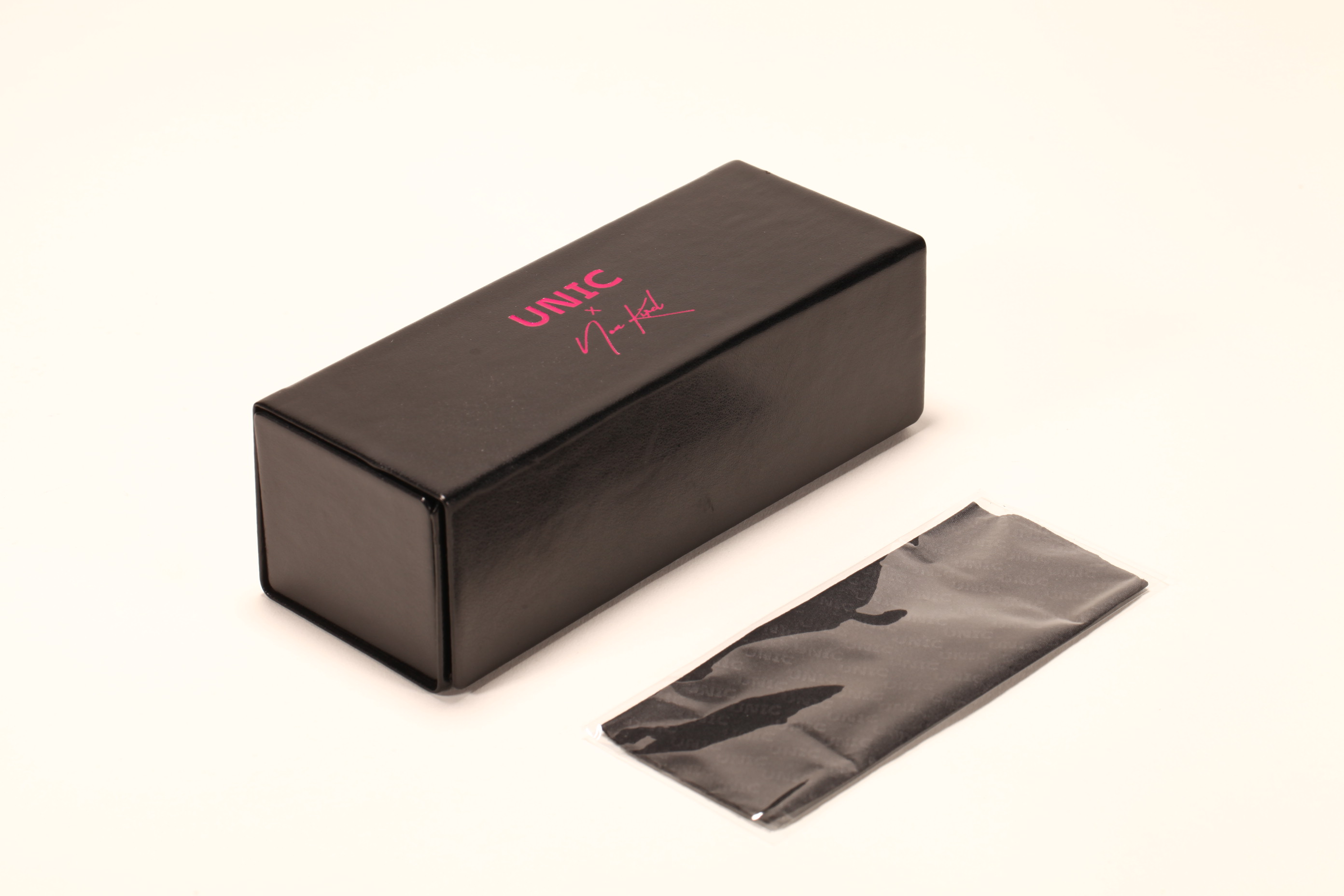 A hand-folded eyeglass case set printed with a pink LOGO, which includes eyeglass cloth,