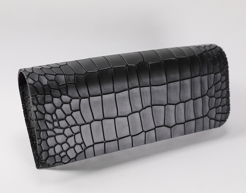 A Black Eyeglass Case with Diamond Lines Printed on It, Which Looks Like A Wallet