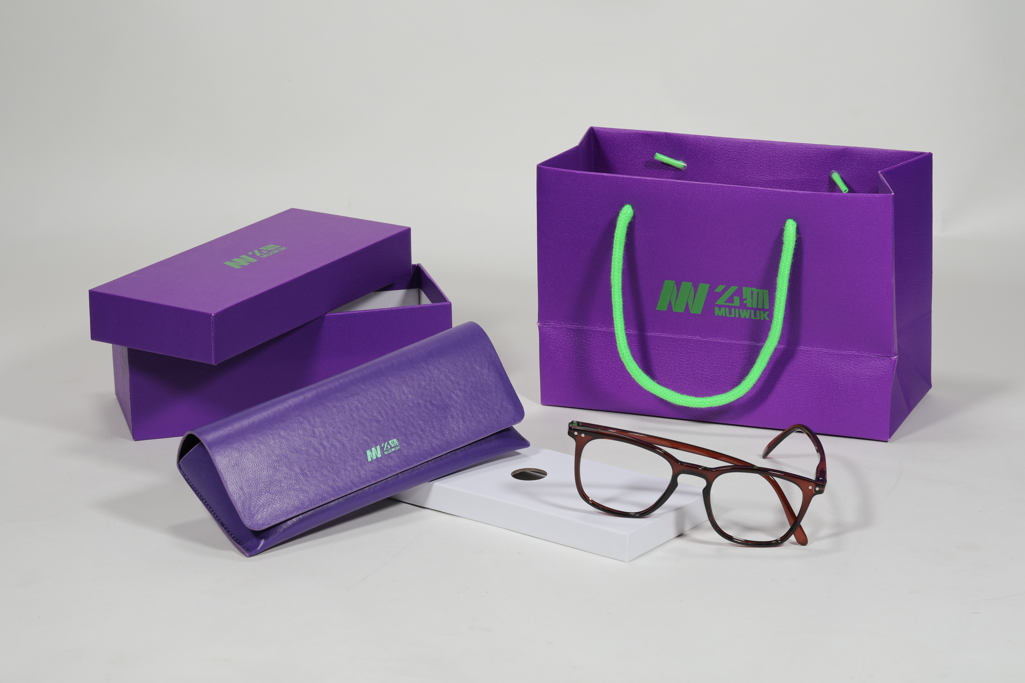 Este set de accesorios para anteojos de la marca "Mijuwlik" presenta un elegante diseño en tonos púrpura, con bolsa, estuche y lentes, exquisito y sofisticado.