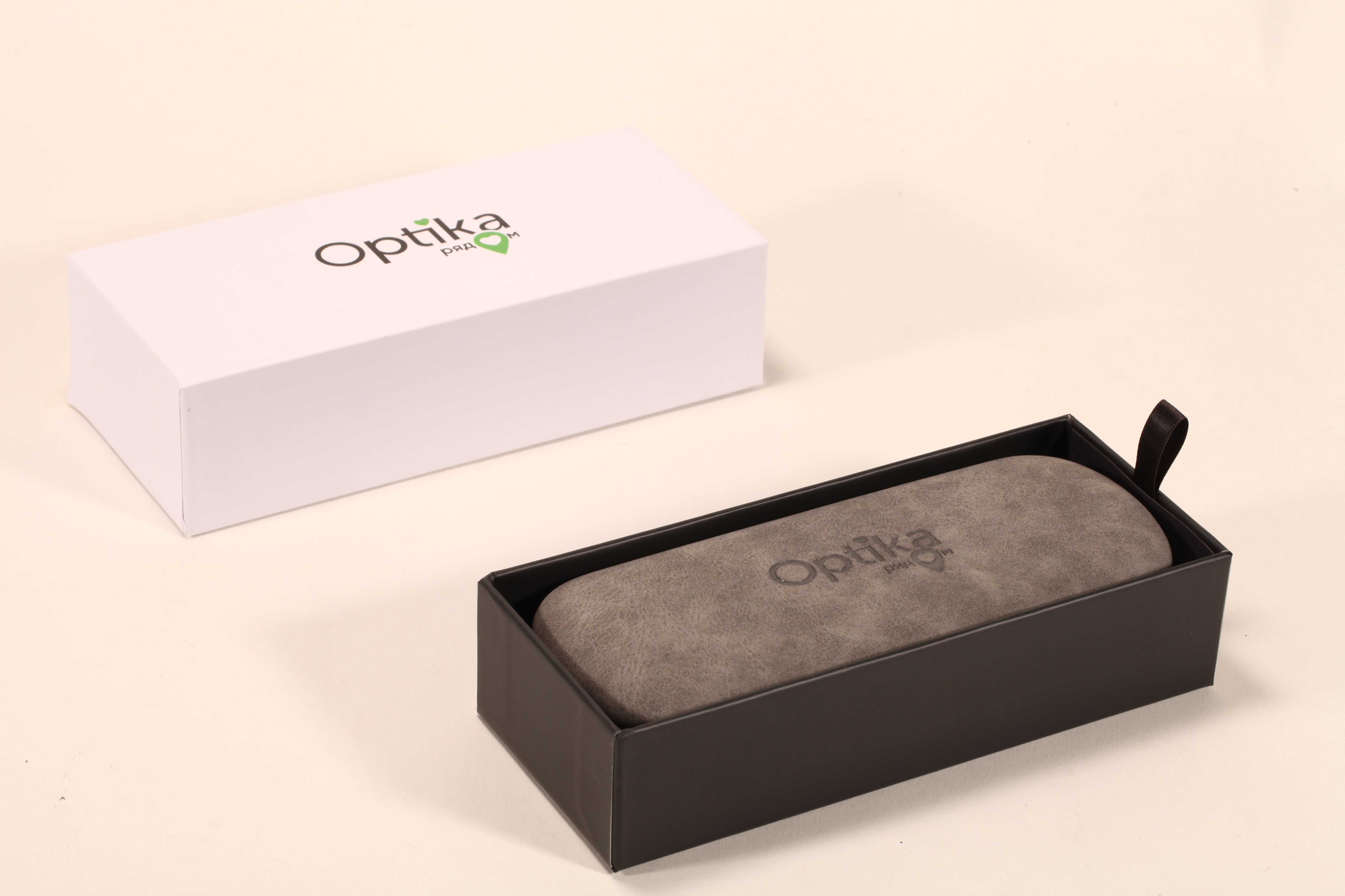 Este set de accesorios para anteojos de Optika incluye dos estuches, una caja y un paño limpiador.
