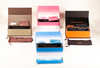 This image displays four rectangular BESO eyewear boxes in varied colors: pink, brown, black, and blue. They feature bold logos in contrasting shades, with some showcasing gradient designs. The clean,