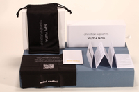 Here is a 50-word English description for the eyewear set shown in the image: This eyewear set features a white paper box and matching soft pouch, measuring 17×4×7 cm. Branded with Christian Wijnants