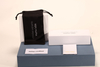 Here is a 50-word English description for the eyewear set shown in the image: This eyewear set features a white paper box and matching soft pouch, measuring 17×4×7 cm. Branded with Christian Wijnants