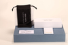 Here is a 50-word English description for the eyewear set shown in the image: This eyewear set features a white paper box and matching soft pouch, measuring 17×4×7 cm. Branded with Christian Wijnants