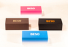 This image displays four rectangular BESO eyewear boxes in varied colors: pink, brown, black, and blue. They feature bold logos in contrasting shades, with some showcasing gradient designs. The clean,