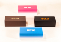 This image displays four rectangular BESO eyewear boxes in varied colors: pink, brown, black, and blue. They feature bold logos in contrasting shades, with some showcasing gradient designs. The clean,