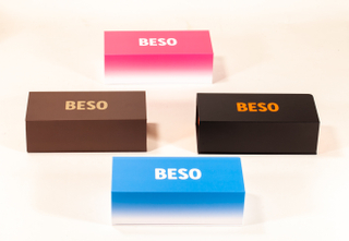 This image displays four rectangular BESO eyewear boxes in varied colors: pink, brown, black, and blue. They feature bold logos in contrasting shades, with some showcasing gradient designs. The clean,