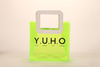 Three translucent bags in green, pink, and blue feature white square handles. The front displays the black text "MARMOTT EYEWEAR".